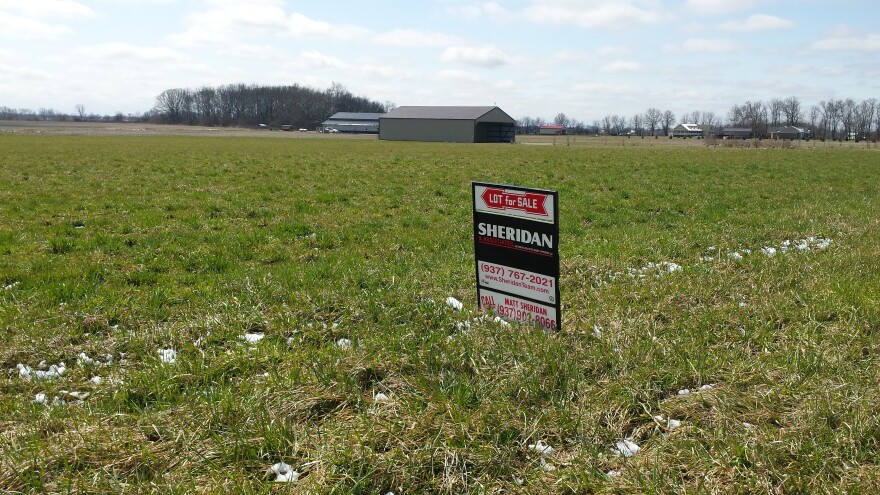 For sale sign in the middle of an agricultural field.