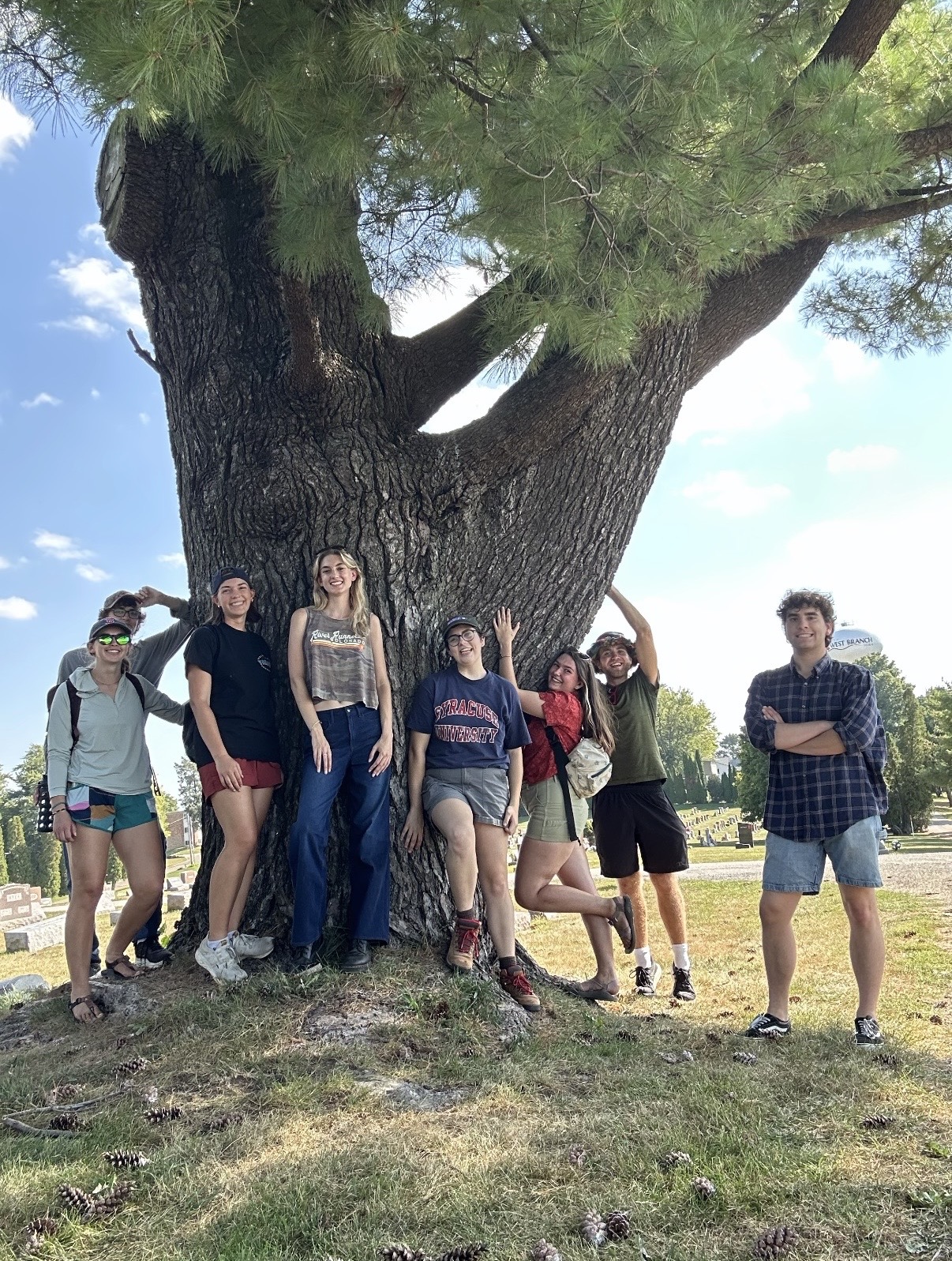 University of Iowa students posing next to a tree in West Branch