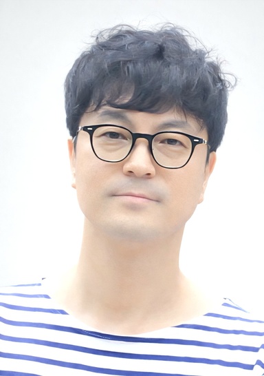 A portrait of an Asian man wearing glasses 