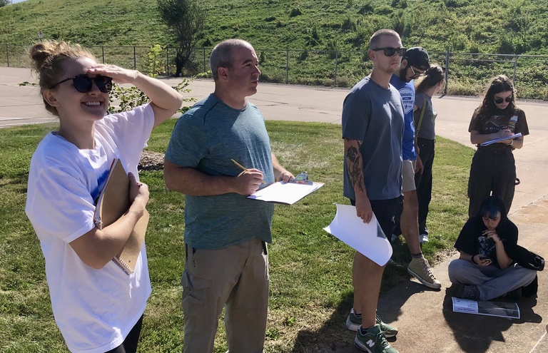 group listening and squinting into sun