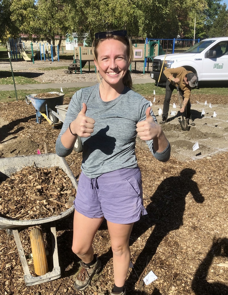 young woman smiling and making thumbs-up sign