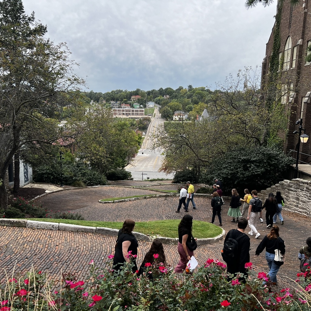 people walking down curvy brick street
