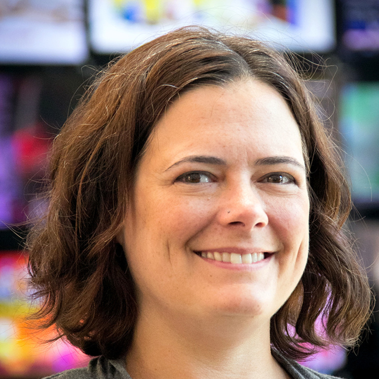 Headshot of smiling woman with white skin, and chin-length brown hair
