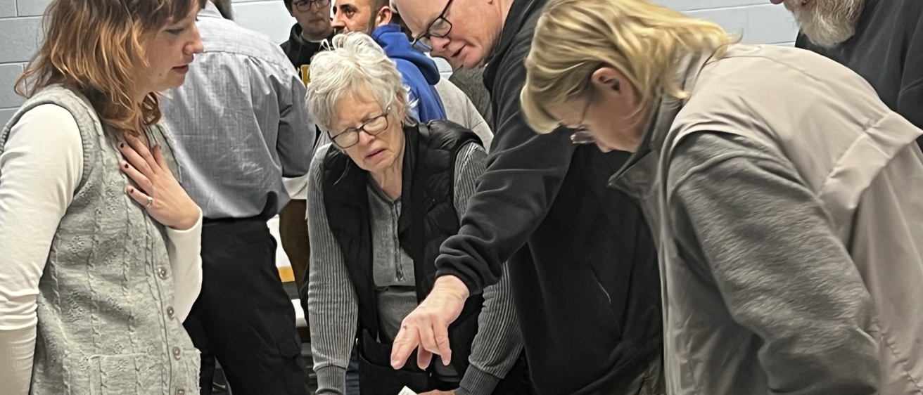 people gathered around a table looking at tables