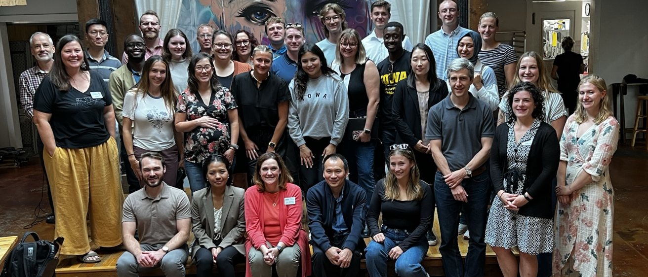 large group photo in front of colorful indoors mural