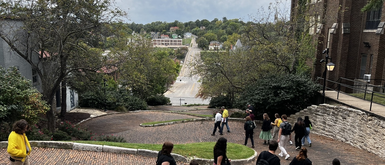 people walking down curvy brick street