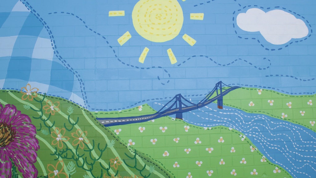 mural of a rural landscape with a bridge across a river