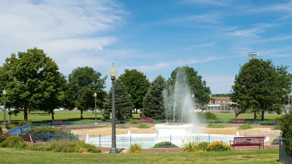 landscape view of a fountain with trees in the background