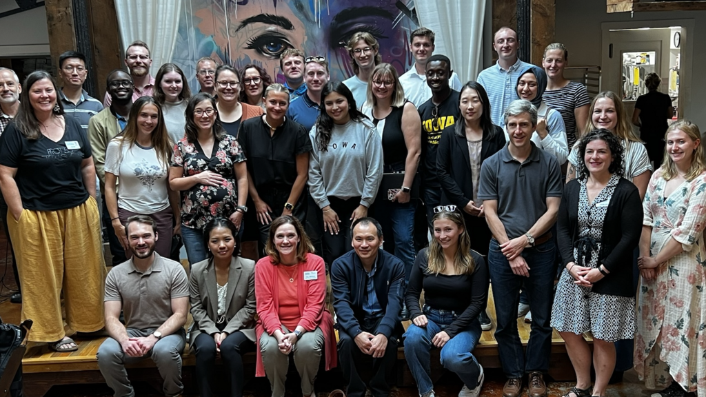 large group photo in front of colorful indoors mural