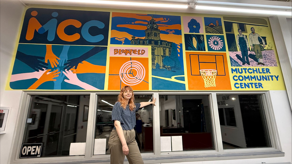 Emily Edwards standing in front of mural