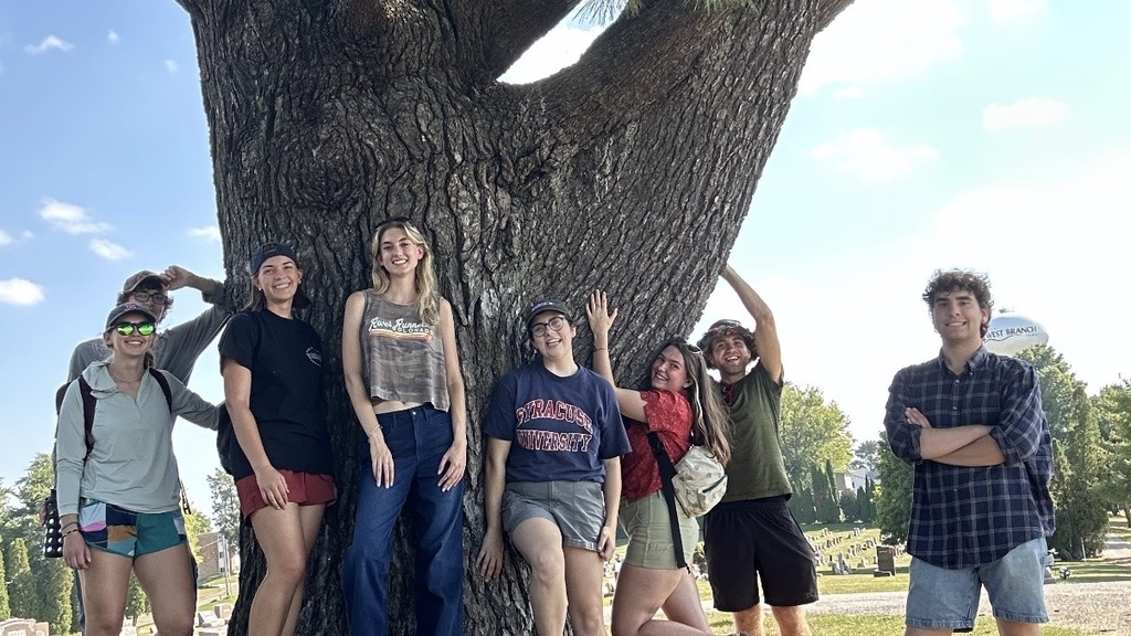 University of Iowa students posing next to a tree in West Branch