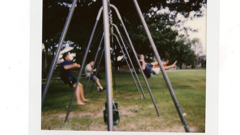 old swing set with people swinging